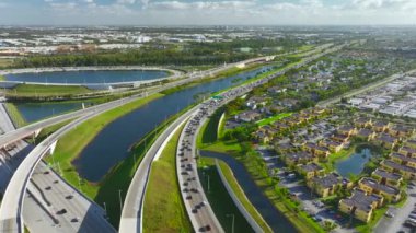 Florida yerleşim bölgesindeki Amerikan apartmanlarının yüksek hız kavşağı yakınlarındaki hava manzarası. ABD 'nin banliyölerinde konut geliştirme örneği olarak yeni aile evleri.