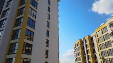 High residential apartment building with monolithic frame and glass windows under construction. Real estate development.