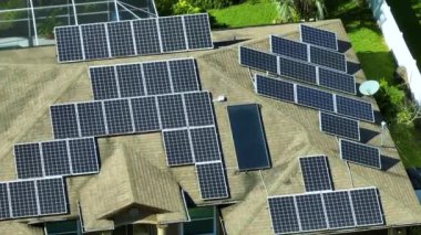 Banliyö bölgesinde temiz ekolojik elektrik enerjisi üretmek için çatısı güneş fotovoltaik panellerle kaplı Amerika 'daki sıradan bir ev. Özerk konut kavramı.