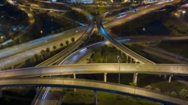 Gece Miami, Florida 'da, hızlı hareket eden araçlar ve kamyonlarla Amerikan otobanının kavşağından bir görüntü. ABD ulaşım altyapısının zaman kaydı.