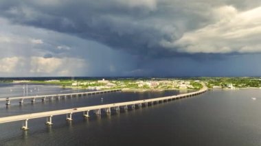 Stormy clouds forming from evaporating humidity of ocean water before thunderstorm over traffic bridge connecting Punta Gorda and Port Charlotte over Peace River. Bad weather conditions for driving.