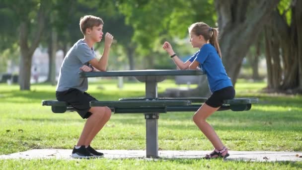 10代の弟と妹が一緒に楽しんでいます 晴れた日に夏の公園でロックペーパーはさみを遊んで幸せな子供たちの男の子と女の子 兄弟姉妹概念との関係 — ストック動画