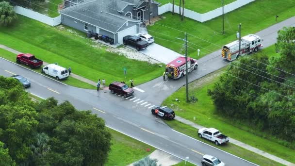 アメリカの通りの事故現場での最初の応答者のトップビュー 米国の郊外道路での自動車事故の被害者を支援する緊急サービス担当者 — ストック動画