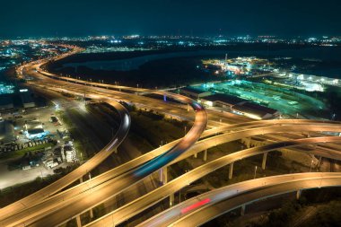 Tampa, Florida 'daki geniş otoyol kavşağının üstünde gece hızlı giden arabalarla. ABD ulaştırma altyapı kavramı.