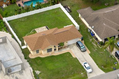 Florida 'nın sakin yerleşim bölgesinde yeşil palmiye ağaçları arasında özel evleri olan küçük bir Amerikan banliyö manzarası..