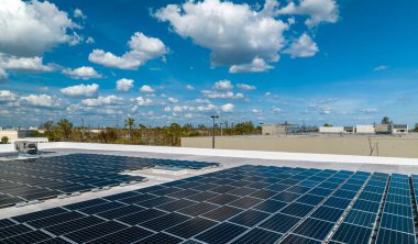 Sanayi binasının çatısına yeşil ekolojik elektrik üretmek için monte edilmiş mavi fotovoltaik panelli güneş enerjisi santralinin hava görüntüsü. Sürdürülebilir enerji konsepti üretimi.
