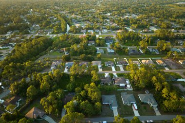 Aerial view of suburban landscape with private homes between green palm trees in Florida quiet residential area.