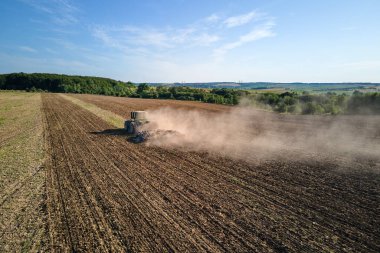 Tarım tarlasını süren traktörün havadan görünüşü yaz mevsiminde tohum ekmek için toprağı hazırlıyor..