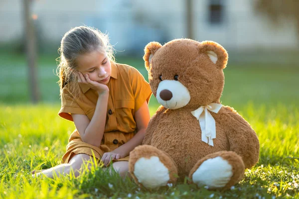 不快乐的小女孩和她的玩具熊朋友在阳光灿烂的夏日后院里共度时光 青春期前孤独的概念和友谊问题 — 图库照片