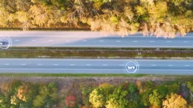 Sonbahar ormanları arasında otostop çekerek kendi kendine giden, yoğun Amerikan otobanında otonom trafiği hızla ilerleyen arabaların görüntüsü. Eyaletler arası ulaşım kavramının geleceği.