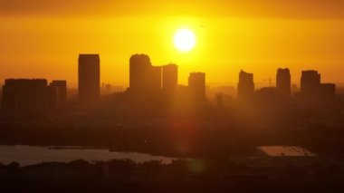 Gün batımında Tampa şehrinin şehir merkezindeki yüksek gökdelen binalarından kalkan yolcu uçağının yukarıdan görüntüsü. Ticari finans bölgesiyle Amerikan megapolis.