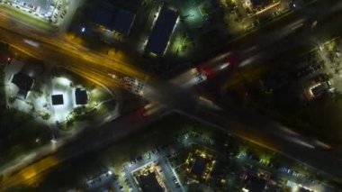 Amerikan çoklu şeritli cadde kavşağının hava görüntüsü. Trafik ışıkları ve gece hareket eden arabalar. ABD 'de kentsel ulaşım zamanı.