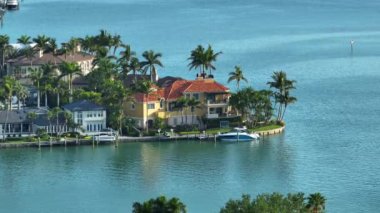 Sarasota, Florida 'daki Bird Key' deki yeşil palmiye ağaçları ve rıhtımlı yatlar arasındaki pahalı deniz manzaralı evler. ABD 'de birinci sınıf konut geliştirme.