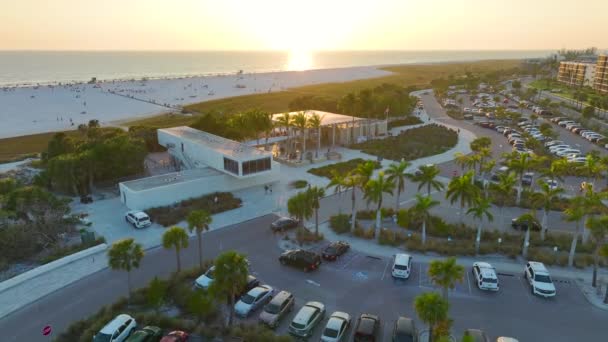サラソータ 米国の有名なシエスタキービーチの前に観光客の車の駐車場の空中ビュー 日没で暖かいフロリダの人気の休暇スポット — ストック動画