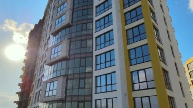 High residential apartment building with monolithic frame and glass windows under construction. Real estate development.