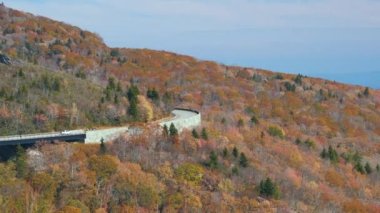 Blowing Rock, Blue Ridge Parkway, North Carolina, ABD yakınlarındaki Linn Cove Viaduct ile dağ sonbaharı manzarası. Sonbahar ormanları arasında manzaralı yolda araba sürmek.