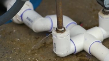Amerikan evindeki su filtreleme sisteminin arızalı bağlantısından sızan plastik borular..