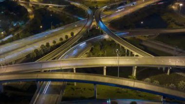 Miami, Florida 'da gece vakti hızlı araba ve kamyonlarla Amerikan otoyolunun kesişme zamanı. ABD ulaşım altyapısının üstünden görüntüle.