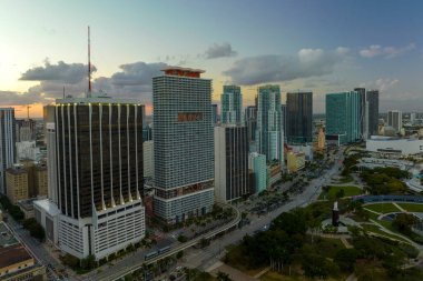 Miami Brickell 'in şehir merkezinin hava görüntüsü, Florida, ABD gün batımında. Modern Amerika 'da arabaları ve metro trafiği olan yüksek gökdelen binaları ve caddeleri.