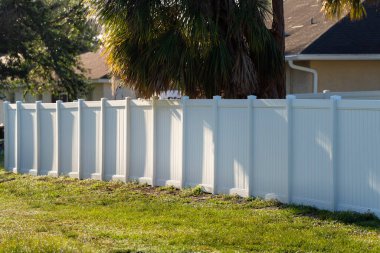White plastic fence for back yard protection and privacy.
