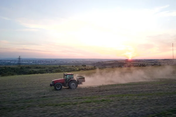 stock image Tractor spraying fertilizers with insecticide herbicide chemicals on agricultural field at sunset.