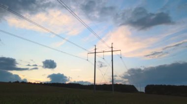 Gün batımında elektrik kabloları olan yüksek voltaj kulesinin karanlık silueti. Elektrik konsepti aktarımı.