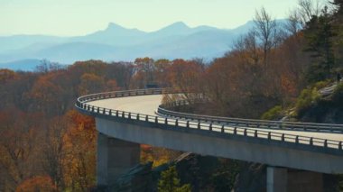 Blowing Rock, Blue Ridge Parkway, North Carolina, ABD yakınlarındaki Linn Cove Viaduct ile dağ sonbaharı manzarası. Sonbahar ormanları arasında manzaralı yolda araba sürmek.