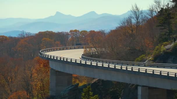 山の秋の風景リンコーブViaduct 近くに吹いてロック ブルーリッジパークウェイ ノースカロライナ州 秋の森の間の風光明媚な道路上で車を運転 — ストック動画