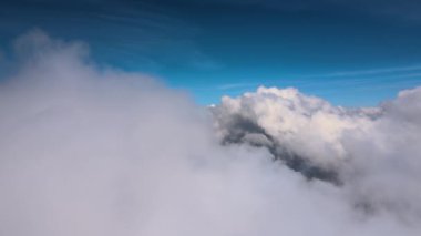 Dünya 'nın yüksek irtifasındaki uçak penceresinden hava manzarası beyaz kabarık kümülüs bulutlarıyla kaplı..