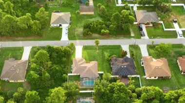 Florida 'nın sakin yerleşim bölgesinde yeşil palmiye ağaçları arasında özel evleri olan küçük bir Amerikan banliyö manzarası..