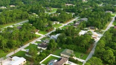 Florida 'nın sakin yerleşim bölgesinde yeşil palmiye ağaçları arasında özel evleri olan küçük bir Amerikan banliyö manzarası..