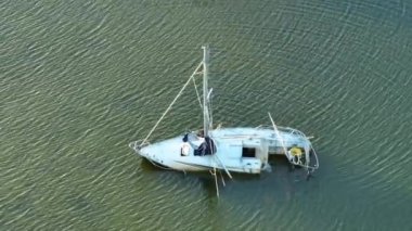 Manasota, Florida 'daki Ian kasırgasından sonra batık yelkenli teknesi sığ körfez sularında terk edildi..
