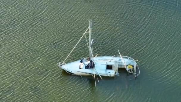 フロリダ州マナソータのハリケーン イアンの後 浅い湾の海に捨てられた転覆した沈没した帆船 — ストック動画