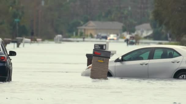 フロリダの住宅街の水に囲まれた立ち往生した車両で浸水したアメリカの通り ハリケーンイアンの自然災害の結果 — ストック動画