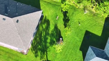 Profesyonel çim biçme işçisi yazın çim biçme makinesi ile çim biçiyor. Kırsal kesimin arka bahçesini düzenlemek.