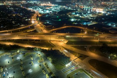 Aerial view of american highway junction at night with fast driving vehicles in Tampa, Florida. View from above of USA transportation infrastructure.