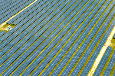 Temiz elektrik enerjisi üretmek için birçok sıra güneş fotovoltaik paneli bulunan sürdürülebilir büyük elektrik santralinin havadan görünüşü. Sıfır emisyon kavramı ile yenilenebilir elektrik.