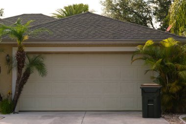 Geniş garaj, çift kapı ve modern Amerikan evinin beton yolu..