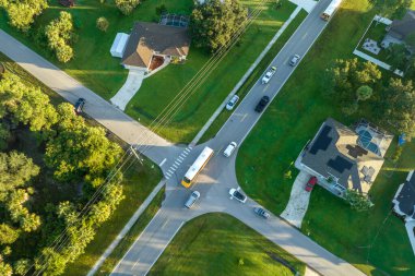 Standart Amerikan okul otobüslerinin en üst görüntüsü sabah erken saatlerde kasaba merkezindeki sokak durağından çocukları alıyor. ABD 'de toplu taşıma.