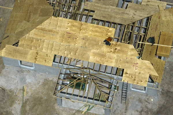 フロリダ郊外に建設中の木造屋根フレーム構造の未完成の住宅に取り組んでいる建築家の空中ビュー — ストック写真