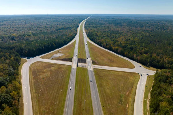 stock image Aerial view of freeway overpass junction with fast moving traffic cars and trucks in american rural area. Interstate transportation infrastructure in USA.