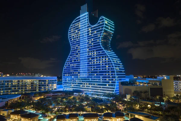 Aerial view of guitar shaped Seminole Hard Rock Hotel and Casino structure illuminated with bright neon colorful lights in Hollywood, Florida.