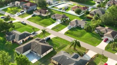 Aerial landscape view of suburban private houses between green palm trees in Florida quiet rural area.