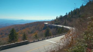 Blowing Rock, Blue Ridge Parkway, North Carolina, ABD yakınlarındaki Linn Cove Viaduct ile dağ sonbaharı manzarası. Sonbahar ormanları arasında manzaralı yolda araba sürmek.