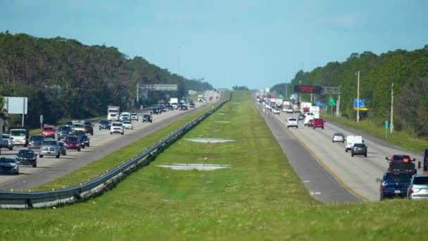 フロリダ州のラッシュ時に高速道路の車とマルチレーンアメリカの高速道路 上昇熱は舗装の上に輝く蜃気楼の効果を与えます 米国の交通インフラの上からの眺め — ストック動画