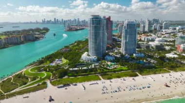 Sıcak Florida güneşinde dinlenen turistlerle birlikte güney sahilinin kumlu yüzeyi. Yüksek lüks otelleri ve apartmanları olan Miami Beach City. Güney Amerika 'da turizm altyapısı.