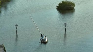 Manasota, Florida 'daki Ian kasırgasından sonra batık yelkenli teknesi sığ körfez sularında terk edildi..