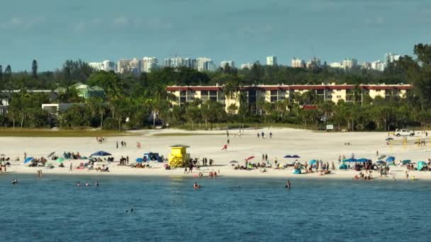 有名なシエスタキービーチ 米国サラソータの柔らかい白い砂 暖かい湾の水と熱いフロリダの太陽の下で日焼けで休暇の時間の入浴を楽しんでいる多くの人々 — ストック動画