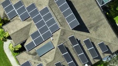 Standard american residential house with rooftop covered with solar photovoltaic panels for producing of clean electrical energy in suburban rural area. Concept of investment in autonomous home.