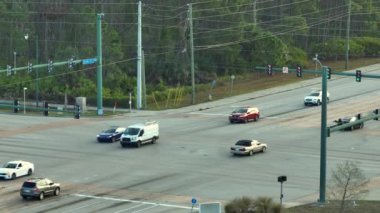 Trafik ışıklarıyla kesişen geniş yol manzaralı. ABD 'de şehir ulaşımı. Amerikan şehir trafiği yukarıdan.